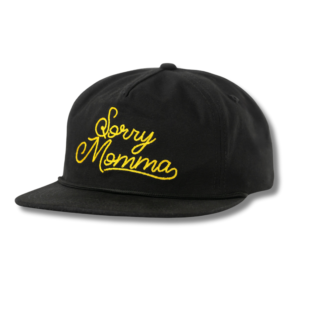 Black snapback cap with yellow ’Sorry Momma’ embroidery on the front.